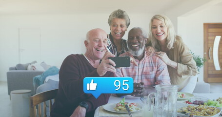 Image of media icons over diverse group of seniors taking selfie