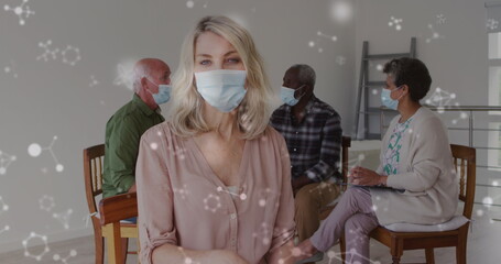 Image of virus icons over diverse group of seniors with face masks