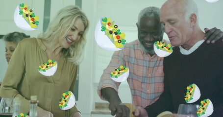 Image of salad icons over diverse group of seniors cooking