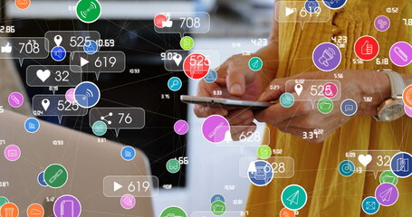 Network of digital icons against mid section of woman using smartphone