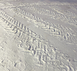 Traces from car wheels on white snow