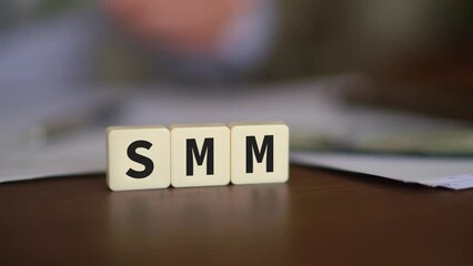 Concept of paying a Social Media Marketing campaign. SMM initials with selective focus and money on the background