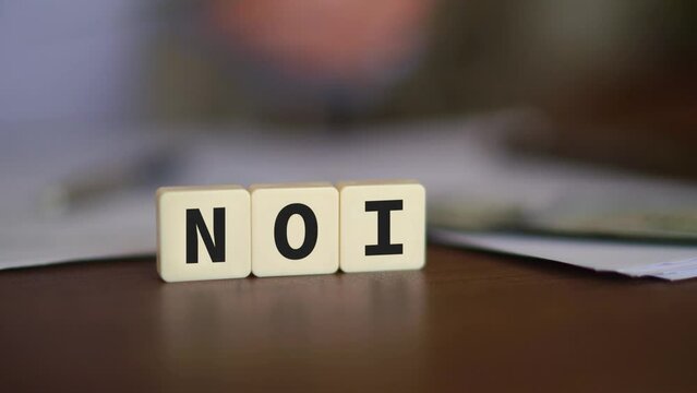 Concept of Net Operating Income. NOI initials with selective focus and money on the background