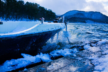 厳しい冬の桟橋とボート、東北の湖