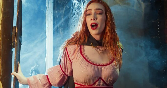 Scared woman with loose hair breaks in tavern in winter evening. Excited young damsel runs through rustic door to report terrible news in pub. Medieval tale scene