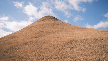 epic hill with blue sky and clouds in the background 