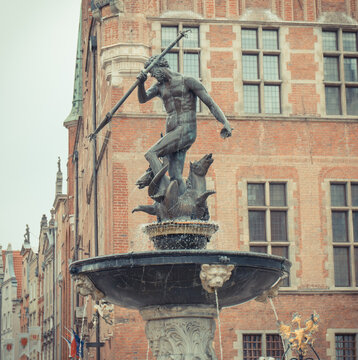 Gdansk, Poland - August 25, 2023: Famous historical fountain of Neptune in center of polish city Gdansk. Vintage photo