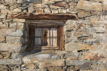 Background stone wall and little window from an old chalet in Savoy