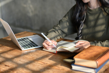 Woman opens laptop, sits and writes