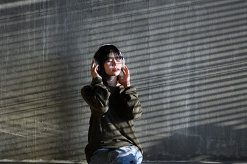 woman in shirt Sitting holding a smartphone, listening to music