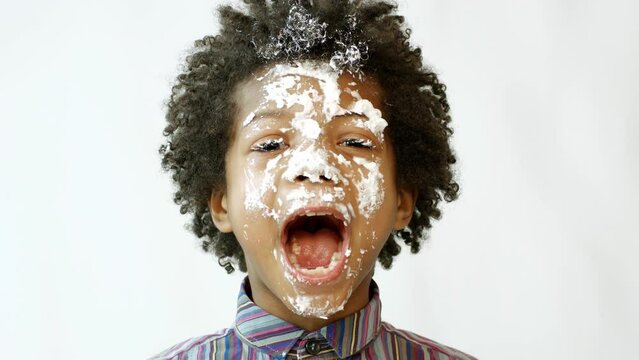 A dark-skinned guy in a white cake. Boy's birthday.