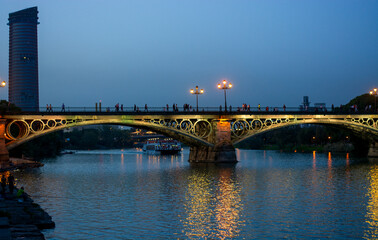The Triana Bridge in the traditional ancient neighborhood of the same name in Seville, Spain - obrazy, fototapety, plakaty