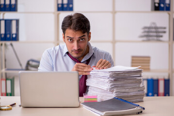 Young male employee and too much work in the office