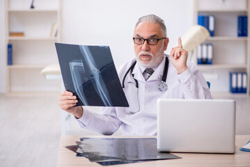 Old male doctor radiologist working in the clinic