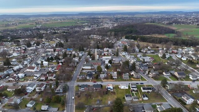 American rown from above at winter day in USA. Aerial top down. Rural area with forest and hills in background.