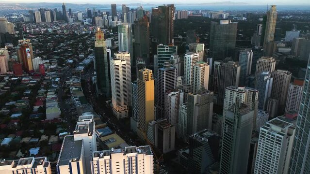 Aerial view tilting away from highrise in sunny Makati, Metro Manila, Philippines