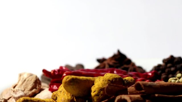 Dried spices together in glass bowl table top spin close 