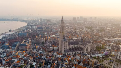 Antwerp, Belgium - July 21, 2023: Spire with the clock of the Cathedral of Our Lady (Antwerp). City Antwerp is located on river Scheldt (Escaut). Summer morning, Aerial View - obrazy, fototapety, plakaty