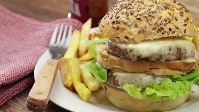 burger double et frites dans une assiette, en gros plan