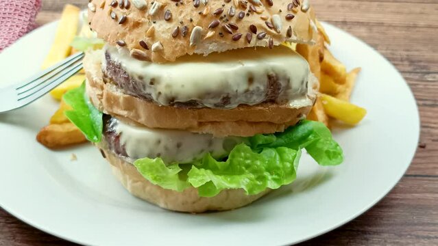 burger double et frites dans une assiette, en gros plan