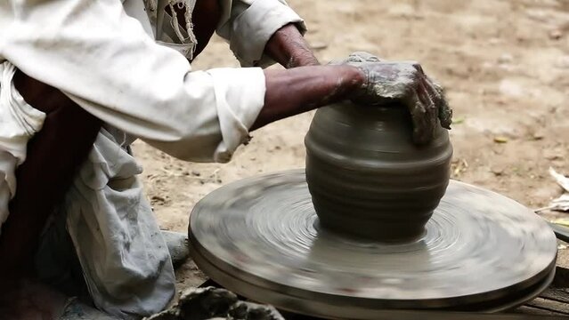 Potter makes earthen water-pot manually for his livelihood in his adobe workshop