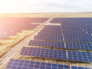 Aerial top view of a solar panels power plant. Photovoltaic solar panels at sunrise and sunset in...