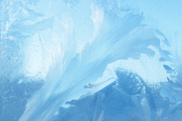 Frost flowers on a frozen flat surface in winter blue ice pattern background texture