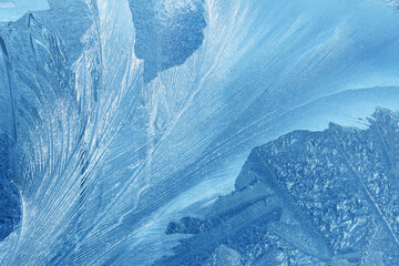 Frost flowers on a frozen flat surface in winter blue ice pattern background texture