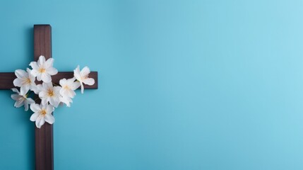A simple wooden cross adorned with white spring blossoms against a calming blue background, symbolizing faith and renewal.