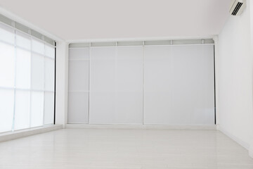 Empty room with white wall and laminated flooring