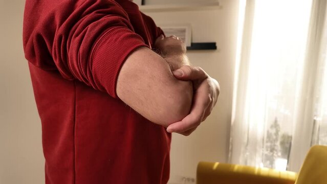 Man with elbow pain at home.