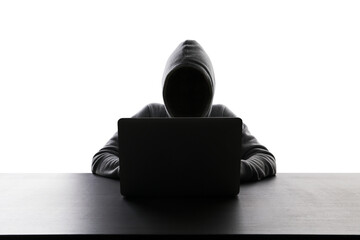 Silhouetted figure in hoodie working on laptop, concept of privacy or hacking