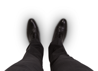 Business professional in black shoes and suit trousers against a white backdrop
