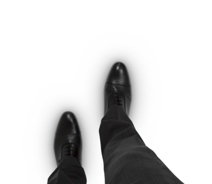 Man's viewpoint looking down at black dress shoes and grey suit pants
