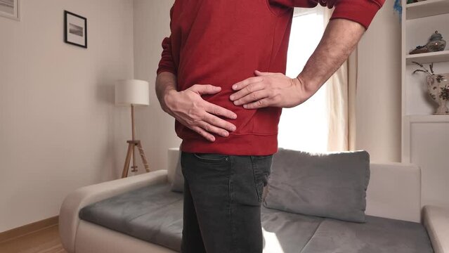 Man with hip, back and sciatica pain at home.