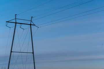 power tower and electric wires against blue sky