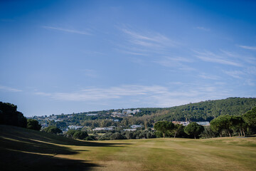 Sotogrante, Spain - January 27, 2024 - Golf course stretching towards a tree-covered hill with...