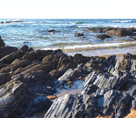 Colorful slate natural rocks at the beach of Vila Nova de Milfontes in Portugal