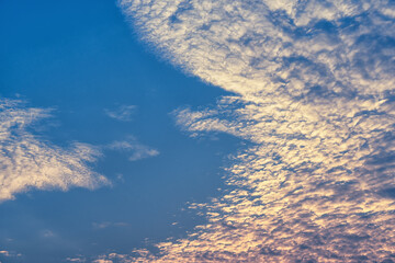 Beautiful waves of clouds against bright blue sky.