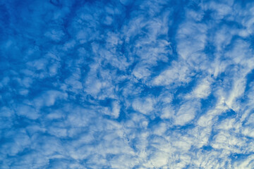 Fototapeta na wymiar Beautiful waves of clouds against bright blue sky.