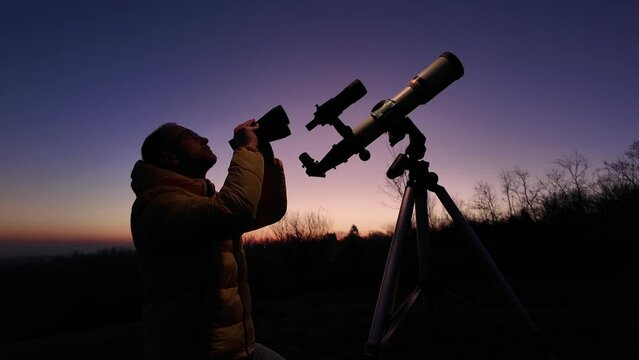 Amateur astronomer looking at the evening skies, observing planets, stars, Moon and other celestial objects with a telescope and binoculars.
