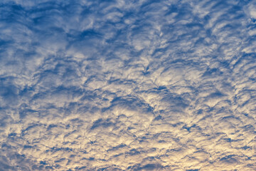 Beautiful waves of clouds against bright blue sky.
