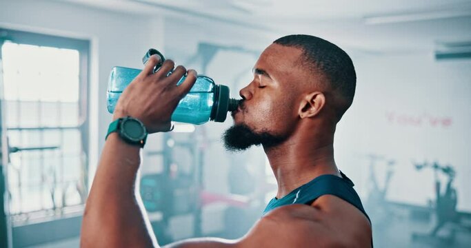 Gym, drinking water and black man with workout, exercise and hydration with progress and training. African person, nutrition and athlete with wellness and health with liquid, fitness and endurance