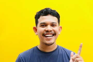 Portrait of the face of an Asian young man with a happy expression, studio shoot