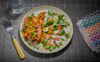 Filled jacket potato with a mixed salad and garnished with salad dressing.