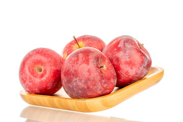 Several ripe red apples on a wooden tray, macro, isolated on white background.