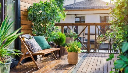 Fototapeta na wymiar Beautiful of modern terrace with wood deck flooring, green potted flowers plants and outdoors furniture. Cozy relaxing area at home back yard. Sunny stylish balcony terrace in the city
