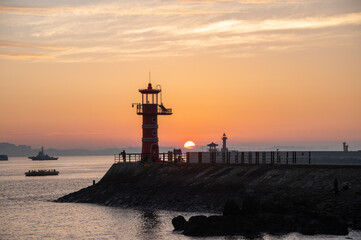 Fototapeta na wymiar Dawn on the beach with a lighthouse view 