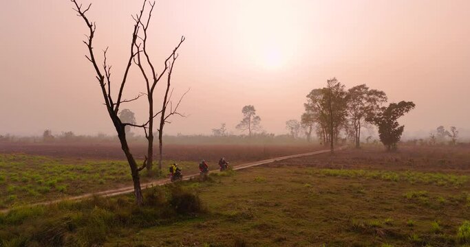 Motorbike rider friends enjoying golden-hour sunset in Terai region Nepal, drone shot captures essence of beauty relationship of people blending nature scenery, landscape travel tourism experience 4K