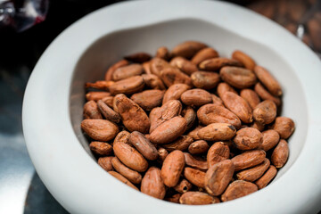 detail of natural cocoa beans displayed on a white plate
